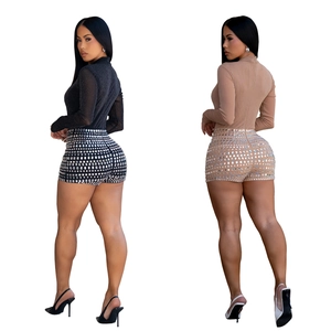 Detail view of sparkly rhinestone shorts and sheer long sleeve tops in black and nude colors