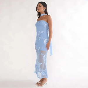 Détail de robe moulante bleu clair avec broderies florales 3D et jupe en tulle