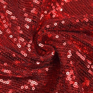 Close-up of sparkling red sequin fabric detailing the texture of a V-neck dress