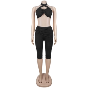 Detail of black two-piece set featuring cross halter top and high-waist biker shorts