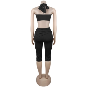 Rear view of black three-piece slim fit set with halter top and skin-tight leggings