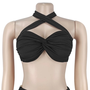 Detail of black halter bikini top featuring a criss-cross design and knotted front pleats