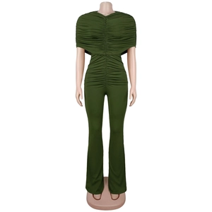 Detailed close-up of dark green ruched fabric and flared leg of an elegant jumpsuit