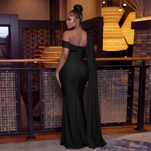 Détail de la robe de soirée noire à une épaule avec fente haute et cape élégante
