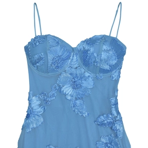 Dettaglio dell'abito in rete azzurro con fiori 3D e scollatura stile corsetto