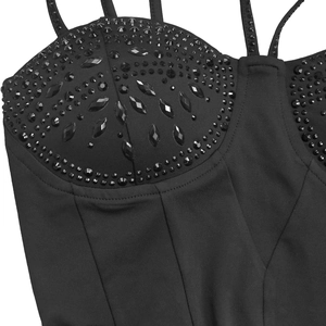Detail of elegant black dress showing intricate rhinestone beadwork and fabric texture