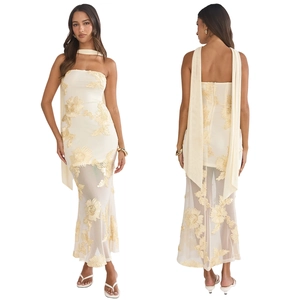 Détail d'une robe moulante dos nu avec broderies florales 3D et écharpe de cou assortie