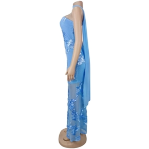 Détail d'une robe de soirée bleue à une épaule avec broderie florale 3D et ourlet transparent