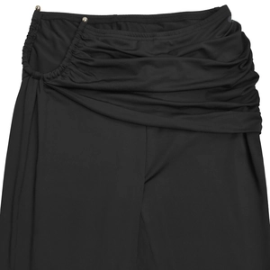 Detailed view of black ruched high-waist pants with decorative gold beads on fabric