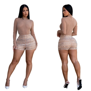 Detail view of sparkly sequined high-waisted shorts and long sleeve bodysuit outfit
