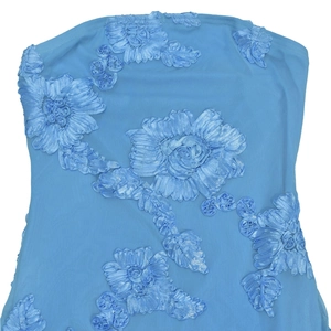 Détail de maille bleu ciel avec broderie florale en ruban 3D sur une robe bustier