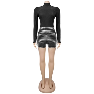 Close-up of black high-waisted shorts with silver geometric rhinestone pattern detail
