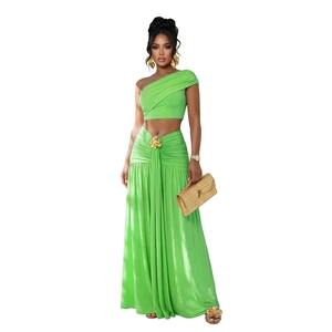 Détail de l'ensemble deux pièces vert citron avec haut asymétrique et boucle de fleur dorée