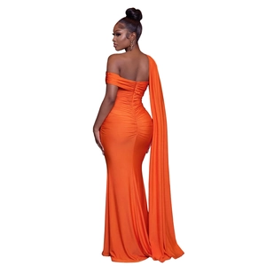 Détail de la robe de soirée orange avec plis au dos élégants et longue cape fluide