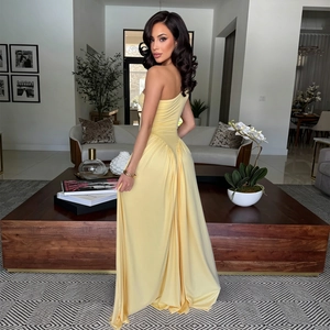 Detail of elegant yellow one-shoulder maxi dress with ruched waist and slit back design