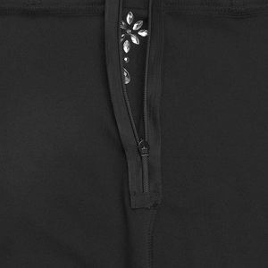 Dettaglio di un abito nero con cerniera verticale e decorazione floreale in strass