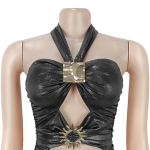 Detail des schwarzen Glitzer-Halterneck-Kleids mit goldenem Sonnenemblem und Schnalle