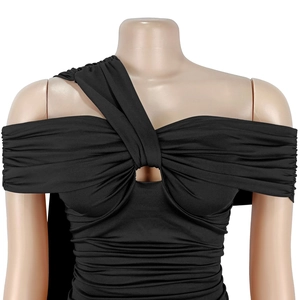 Détail de la robe noire chic à épaules dénudées avec fronces et découpe frontale