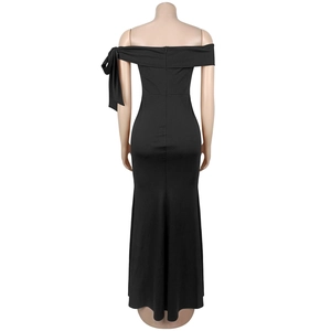 Détail de robe de soirée noire épaules dénudées avec un grand nœud décoratif sur l'épaule