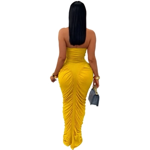 Detail view of yellow ruched bodycon maxi dress with an elegant mermaid hem and backless cut