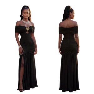 Détail d'une robe longue noire à épaules dénudées avec nœud doré et fente haute