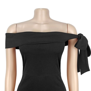 Détail du grand nœud élégant sur l'épaule de la robe noire chic avec encolure à épaules nues
