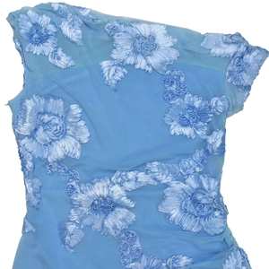 Detailed view of light blue mesh fabric with heavy 3D floral embroidery and lace details