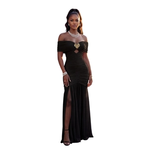 Détail d'une robe noire à épaules dénudées avec boucle papillon dorée et fente haute