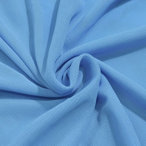 Gros plan détaillé sur la texture du tissu en maille bleu clair de cette robe d'été sexy