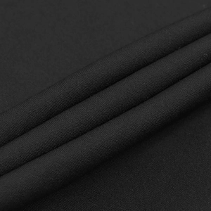 Dettaglio ravvicinato della trama del tessuto nero con elegante drappeggio morbido e fibra