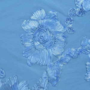 Gros plan sur la broderie de fleurs en ruban bleu clair sur tissu en maille pour robe