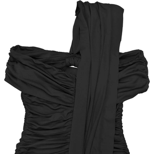 Détail d'une robe noire plissée montrant le tissu froncé et la bandoulière drapée