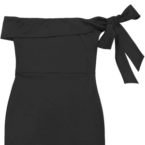 Détail d'une robe noire élégante à épaules dénudées avec un grand nœud sur l'épaule gauche