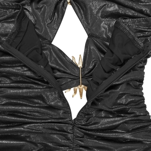 Detail eines schwarzen Paillettenkleids mit Faltenstoff und goldenem Metallstern-Akzent