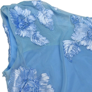 Detail of light blue dress showing mesh fabric with 3D floral embroidery and hidden zipper