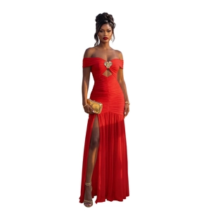Détail de la robe rouge à épaules dénudées avec ornement de cœur doré et design plissé