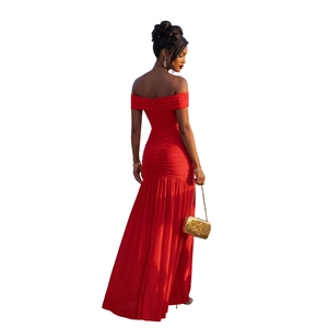 Détail de la robe rouge à épaules dénudées avec plis élégants et une coupe longue fluide