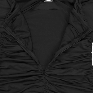 Détail montrant la fermeture éclair invisible et le tissu noir froncé élégant de la robe