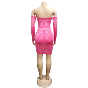 Détail d'une robe moulante rose avec motifs floraux et géométriques en strass brillants