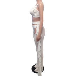 Detailed side view of white mesh trousers featuring pearls and ruffled chiffon trim