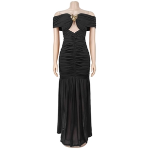 Détail d'une robe noire plissée à épaules dénudées avec boucle dorée et décolleté ajouré