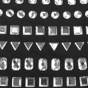 Detail of assorted silver rhinestones in geometric shapes on black mesh fabric