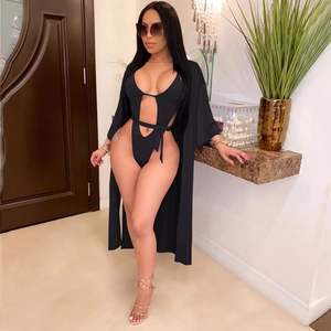 Détail d'un maillot de bain noir ajouré avec un paréo assorti léger porté par un mannequin