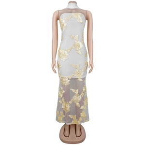 Détail d'une robe longue blanche sans bretelles avec broderie florale et tissu en mesh