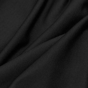 Macro detail of black ribbed fabric texture showing the pleated knit material of the dress