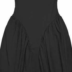 Detailed close-up of V-shaped waist seam and elegant pleated draping on a black dress