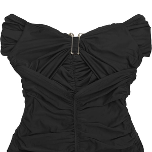 Détail d'une robe noire à épaules dénudées avec tissu froncé et boucle en métal doré
