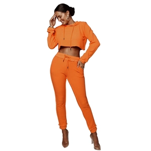 Dettaglio del completo sportivo da donna con felpa corta e pantaloni in colore arancione