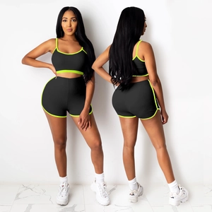 Détail d'ensemble de yoga côtelé noir avec liseré vert fluo sur le haut et le short