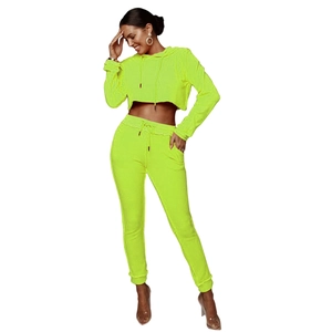 Dettaglio della felpa corta giallo neon e pantaloni sportivi coordinati per donna